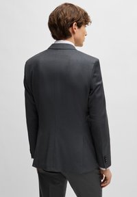 Grijze op maat gemaakte blazer met een gladde textuur, met notch revers en twee knopen. Heeft een vented rug en een slim-fit ontwerp.