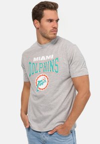Šedé bavlněné tričko s potiskem "MIAMI DOLPHINS" a kruhovým logem delfína v azurové a oranžové barvě, s klasickým kulatým výstřihem a krátkými rukávy.