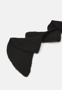 Sort strikket tørklæde med en tekstureret overflade, der har et asymmetrisk design med spidse ender. Blødt og let materiale.