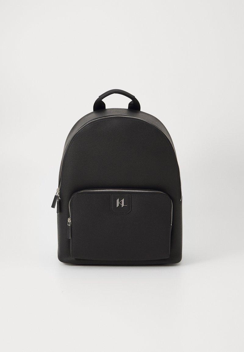 Black backpack with a rounded top, made of textured material, featuring a front zip pocket and a handle on top. Silver hardware accents.