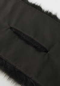 Black, padded fabric with a soft faux fur trim and an inset pocket. The texture is smooth with a matte finish, complementing the plush edge.
