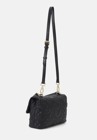 Svart läder axelväska med en quiltad mönster, guldfärgad hårdvara och justerbar rem. Har ett präglat logotyp på framsidan.