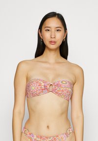 Bikini top s kvetinovým vzorom v ružovej, oranžovej a žltej farbe, s prekrúteným dizajnom a obručami ako akcentmi. Hladká textúra tkaniny.