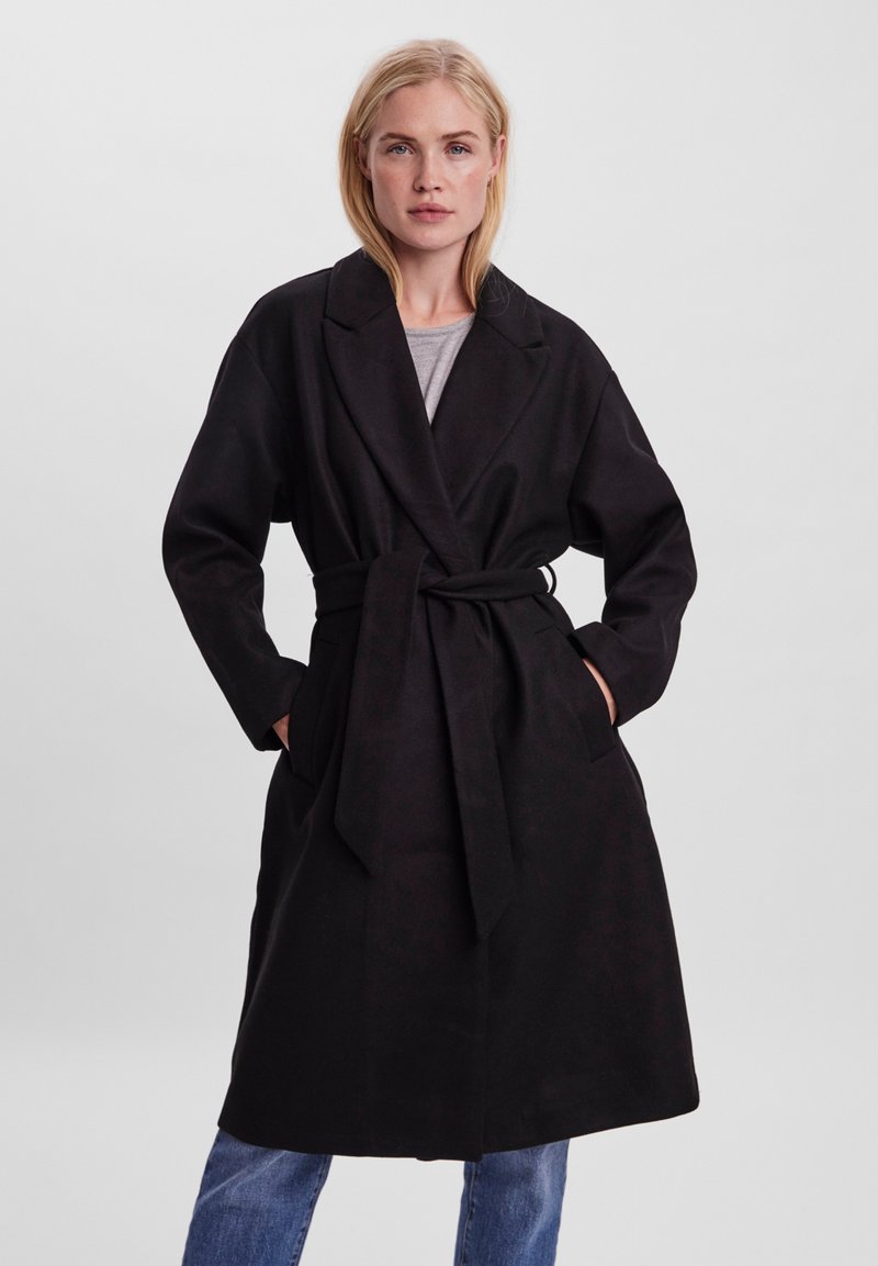 Cappotto avvolgente nero con cintura, maniche lunghe e tasche laterali; realizzato in un tessuto morbido, presenta un colletto a scollo e una linea dritta.