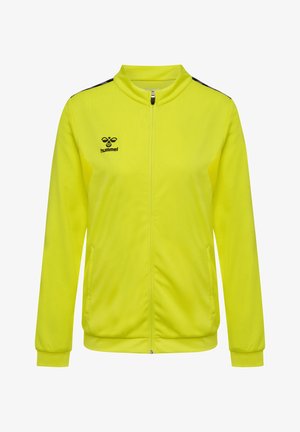 Gelbe Trainingsjacke mit Reißverschluss, hohem Kragen und schwarzen Akzenten an den Schultern. Hergestellt aus strukturiertem Stoff, mit seitlichen Taschen.