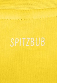 Gelber Stoff mit glatter Textur zeigt den weißen Text "SPITZBUB", der auffällig in einer schlichten, modernen Schriftart dargestellt ist.