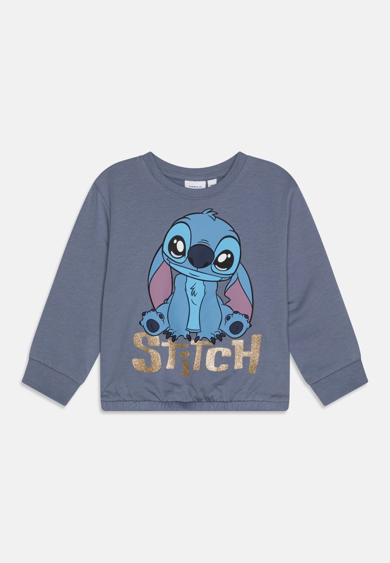 Grå hettegenser med et tegneserie-Print av Stitch i blått med store øyne, kombinert med "STITCH" i gullglitterbokstaver nederst.