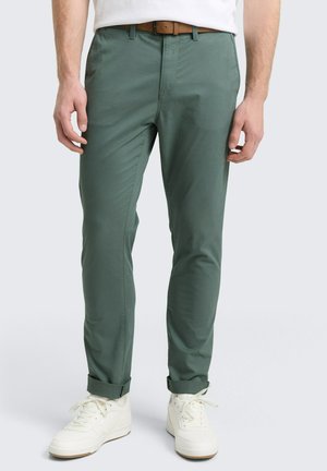 Grønne, slim-fit chinos lavet af letvægtsmateriale, med flad front, bæltestropper og opstammede manchetter, parret med hvide sneakers.