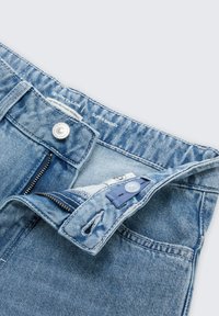 Lichtblauwe denim jeans met een super losse pasvorm, voorzien van een ritssluiting, knoopsluiting en zichtbare stikdetails. Gemaakt van gerecycled materiaal.