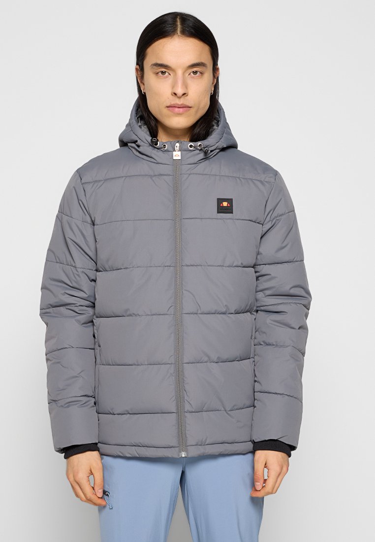 Chaqueta tipo puffer en gris claro, con capucha, cierre de cremallera, puños elásticos y un pequeño parche con logotipo en el pecho con un diseño acolchado.