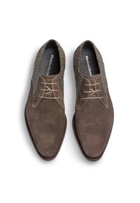 Chaussures en cuir brun texturé avec un bout lisse et des lacets de couleur claire. Les panneaux latéraux présentent un design tissé contrasté.