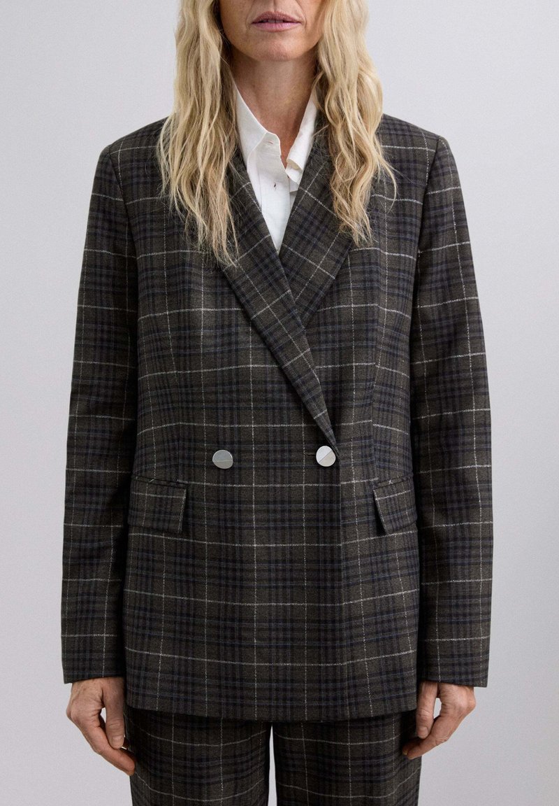 Blazer de cuadros de doble botonadura en marrón oscuro y gris, con botones plateados, dos bolsillos frontales y una tela suave y texturizada.