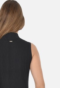 Top senza maniche nero con un motivo testurizzato, caratterizzato da un collo alto e un piccolo dettaglio con logo metallico sul retro.