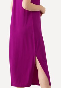 Fuchsia jurk met een ontspannen pasvorm, voorzien van een zijsplit voor een gemakkelijke beweging. Vriendelijke stof met een gladde textuur.