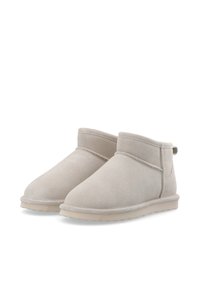 Stivaletti alla caviglia beige chiaro realizzati in morbido camoscio, con punta rotonda, dettagli cuciti e suola in gomma flessibile.