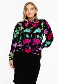 Schwarze Bluse mit floralen Muster in Pink, Lila und Grün. Mit Knopfverschluss vorne, langen Ärmeln und leichter Raffung an den Manschetten.