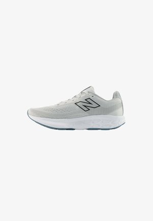 Zapatilla deportiva de color gris claro con logotipo negro "N", suela blanca acolchada y parte superior de malla transpirable, diseñada para correr.