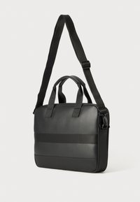 Black messenger bag with handles and an adjustable strap. Smooth material with a horizontal accent stripe. Rectangular shape, solid texture.