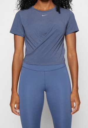 T-shirt Nike bleu marine avec une coupe slim et des manches courtes, présentant un col rond et un léger design tordu à l'avant.