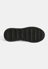 Schwarze Schuhsohle mit strukturierter Oberfläche, die horizontale Rillen für den Grip und einen erhöhten Rand für Langlebigkeit aufweist.