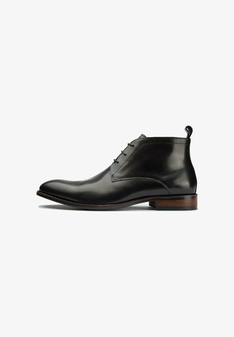 Black leather ankle boots with a sleek, pointed toe, featuring three eyelets for laces and a wooden heel accent.