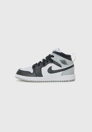 High-Top Nike Air Jordan Sneaker in Schwarz, Weiß und Grau mit schwarzen Schnürsenkeln und Sohlenakzenten, seitlich auf weißem Hintergrund gezeigt.