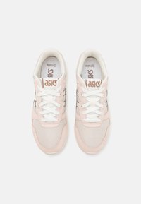 ASICS sneakers with a light pink and beige upper, featuring mesh and suede material, white laces, and black accent lines on the sides.