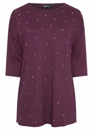 Purple short-sleeve top in soft fabric, adorned with small silver star embellishments, featuring a loose fit and side slits.