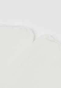 Hvide bomuldsokker med en glat tekstur og et let ribbet mønster øverst. Rundede kanter og ingen synlige mærke- eller hardwaredetaljer.