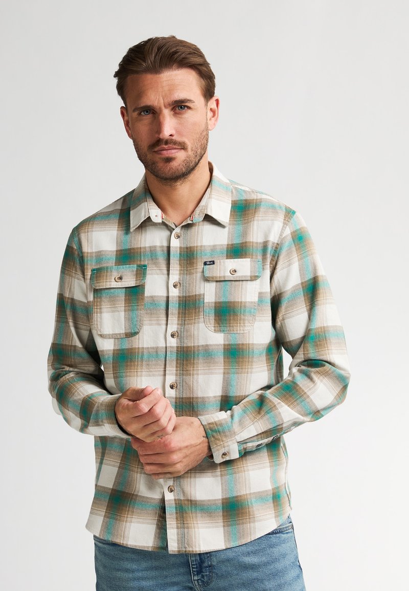 Geruit flanellen overhemd met donkergroene, bruine en witte patronen, twee borstzakken en een knoopsluiting aan de voorkant. Gemaakt van geweven stof met een zachte textuur.