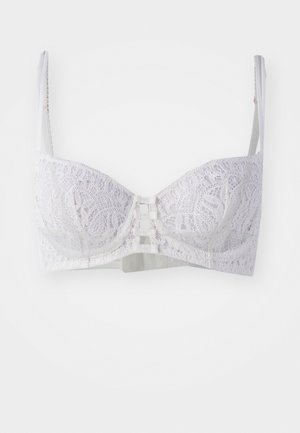 White lace bra with structured cups, featuring intricate floral patterns, adjustable straps, and a three-hook closure at the center.
