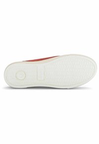 Die Schuhsohle verfügt über eine strukturierte weiße Gummibasis mit einem runden Logo und einem Muster aus kleinen Quadraten für besseren Grip.