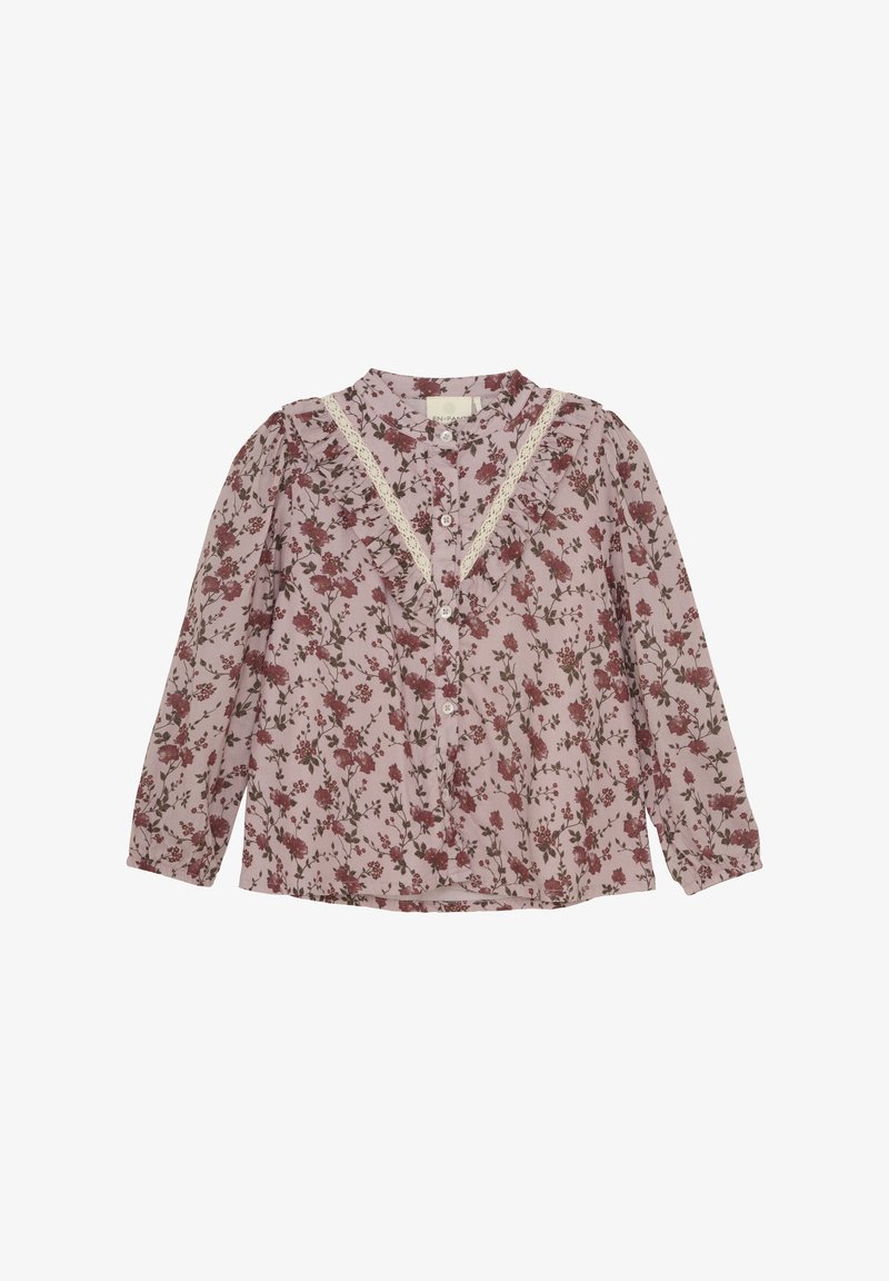 Bluzka z długim rękawem w miękkim różowym kolorze, zdobiona kwiatowym wzorem w czerwieni i zieleni. Ozdobiona koronkowym wykończeniem i zapięciem na guziki z przodu.