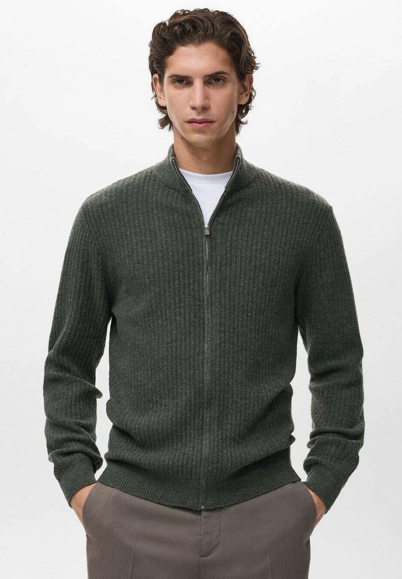 Maglione a coste verde scuro con collo zip, maniche lunghe e polsini aderenti. Realizzato in materiale morbido, ha una texture liscia e un design aerodinamico.