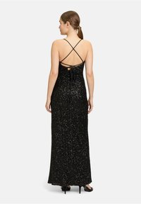Schwarzes Pailletten-Abendkleid mit taillierter Silhouette, Spaghettiträgern, gekreuztem Rückendesign und Schnürdetail am Rücken. Bodenlang.