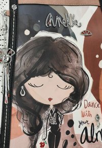 Eine bedruckte Lederhandtasche mit einer Charakterillustration, die dunkles Haar, eine Blume und metallische Akzente zeigt. Die Farben umfassen neutrale und pastellene Töne.