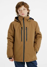 Braune wasserdichte Jacke mit durchgehendem Reißverschluss, verstellbarer Kapuze und drei Fronttaschen. Mit schwarzen Akzenten und Klettverschluss-Manschetten.