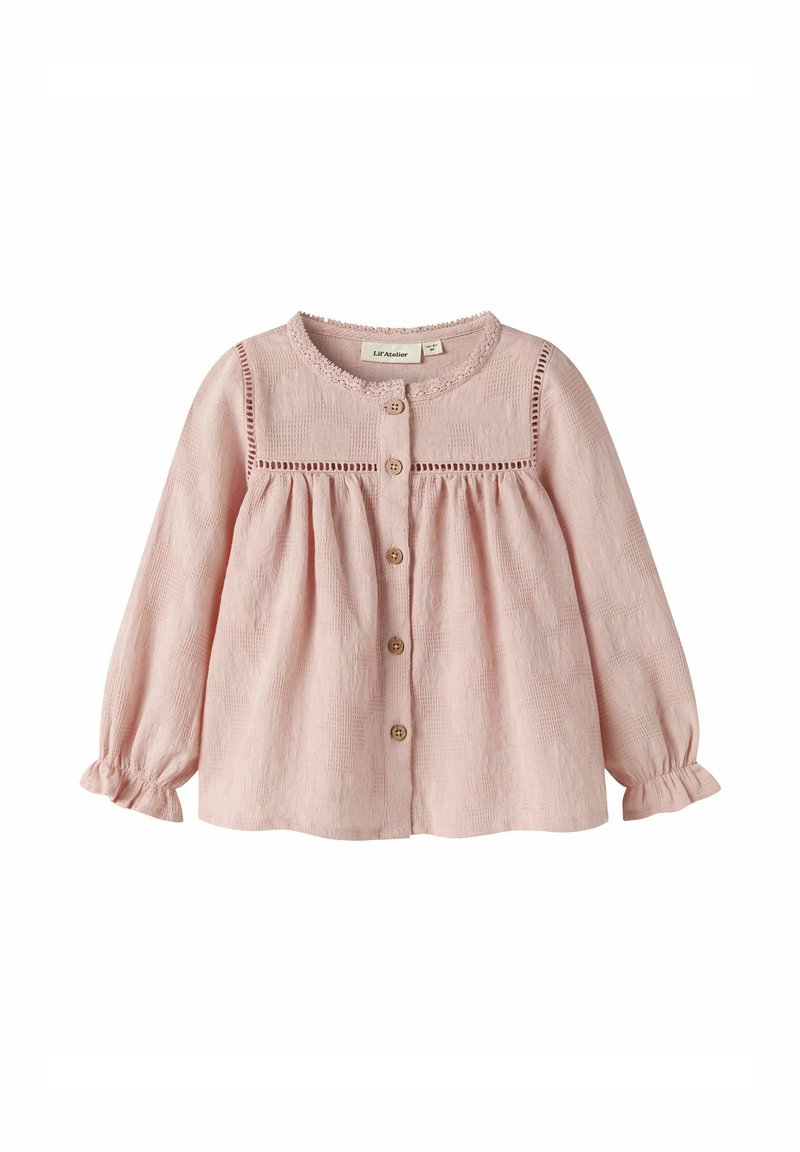 Blusa per bebé a maniche lunghe di un leggero colore rosa con bottoni di legno, bordino in pizzo attorno al colletto e alla spallina, e leggero volant alle maniche con polsini.