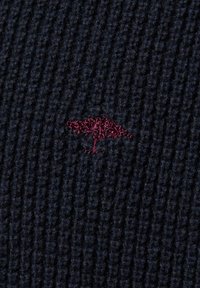 Marineblaue Strickware mit einem strukturierten, gerippten Muster und einem kleinen, dunkelroten, gestickten Logo, das einem stilisierten Tier ähnelt.