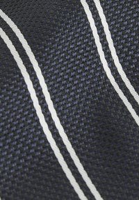 Tessuto navale resistente con superficie texturizzata, caratterizzato da due strisce bianche che corrono parallele su tutto il materiale.