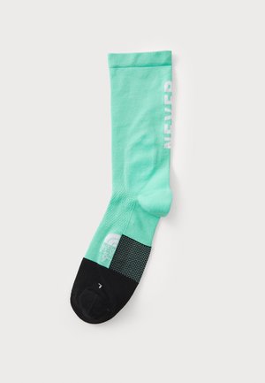 Aqua green sock with black toe and heel accents; features breathable mesh pattern and "NEVER STOP EXPLORING" text on the side.