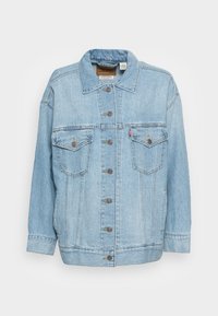 Ljusblå denimjacka med krage, knäppning fram, två bröstfickor och bruna knappdetaljer. Avslappnad passform och synlig sömnad.