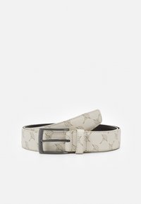 Curea din piele de culoare bej deschis, cu un model floral embosat, având un cataramă metalică neagră și o textură netedă.