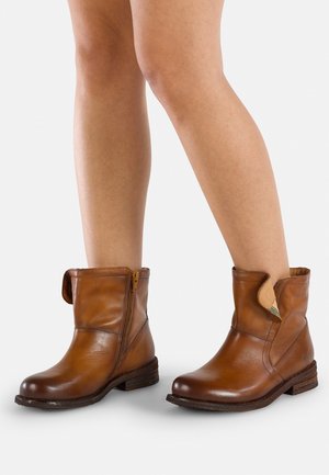 Bottes de cheville en cuir marron avec une fermeture éclair sur le côté, bout arrondi, design de revers et talon empilé. Finition texturée avec des détails de couture.