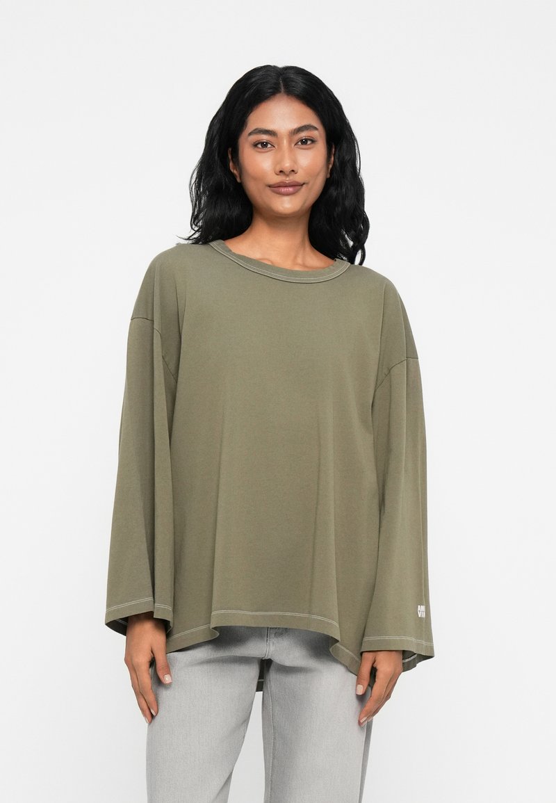 Χακί πουκάμισο με μακριά μανίκια και χαλαρή εφαρμογή, στρογγυλή λαιμόκοψη, κατεβασμένους ώμους και ίσιο στρίφωμα. Απλή ραφή και τονισμένο λογότυπο.