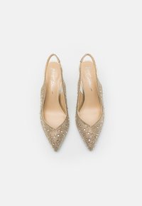 Tacchi slingback beige con punta affusolata, decorati con scintillanti strass. Interno liscio con marchio distintivo visibile.