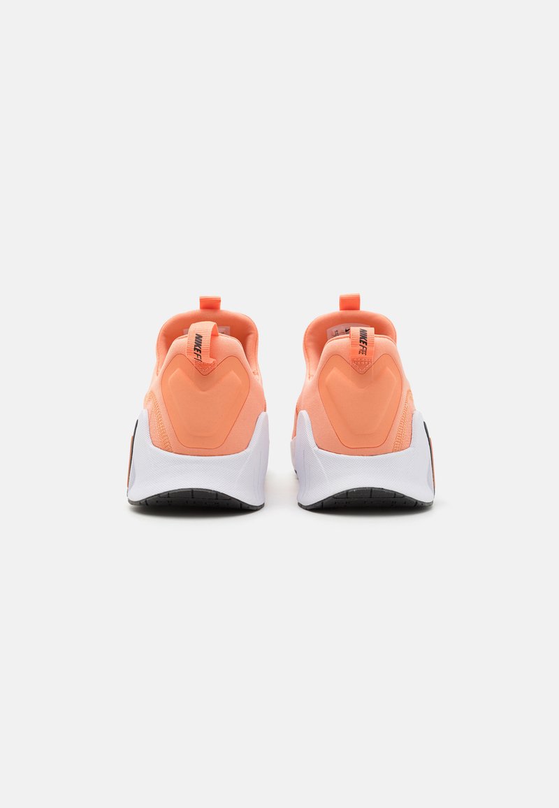 Zapatillas deportivas naranjas con un empeine de tela texturizada, tirador en el talón y suelas blancas con patrones de tracción negros, vistas desde la parte posterior.