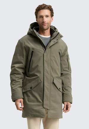 Parka verde oliva con cappuccio, dotata di tasche con zip e bottoni a pressione, e di una patta frontale. Realizzata in un tessuto durevole e testurizzato.