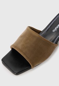 Chinelo mule preto com biqueira quadrada, tira larga de tecido castanho e costura branca visível na palmilha.