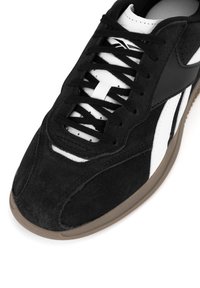 Mustad nahast tennisetoss valgete nahainetega, võrkmaterjali detailide ja pruuni kummitalda. Omab musti paelte ja väljapaistvaid disainijooni.